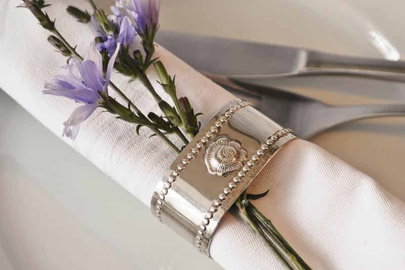 Servietten-Detail mit Wiesenblume und Besteck
