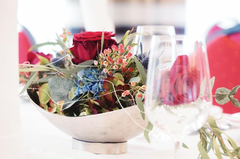 Festliche Tischdekoration mit roten Rosen und Hortensien